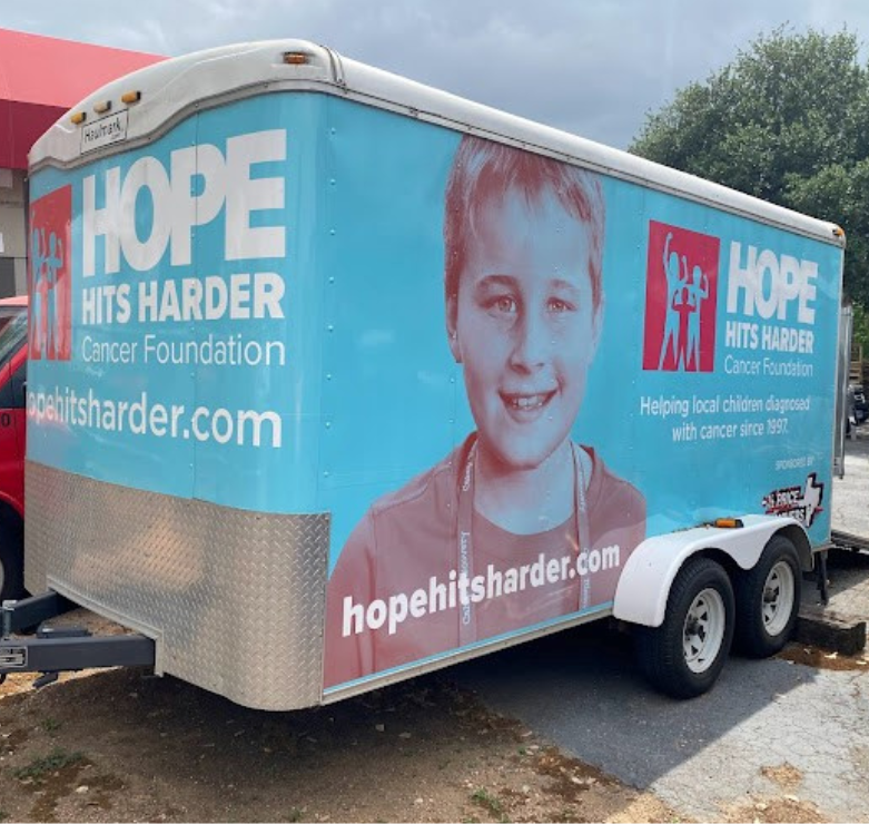 Half Price Movers crew and volunteers in front of branded HPM truck at Snack Pak event